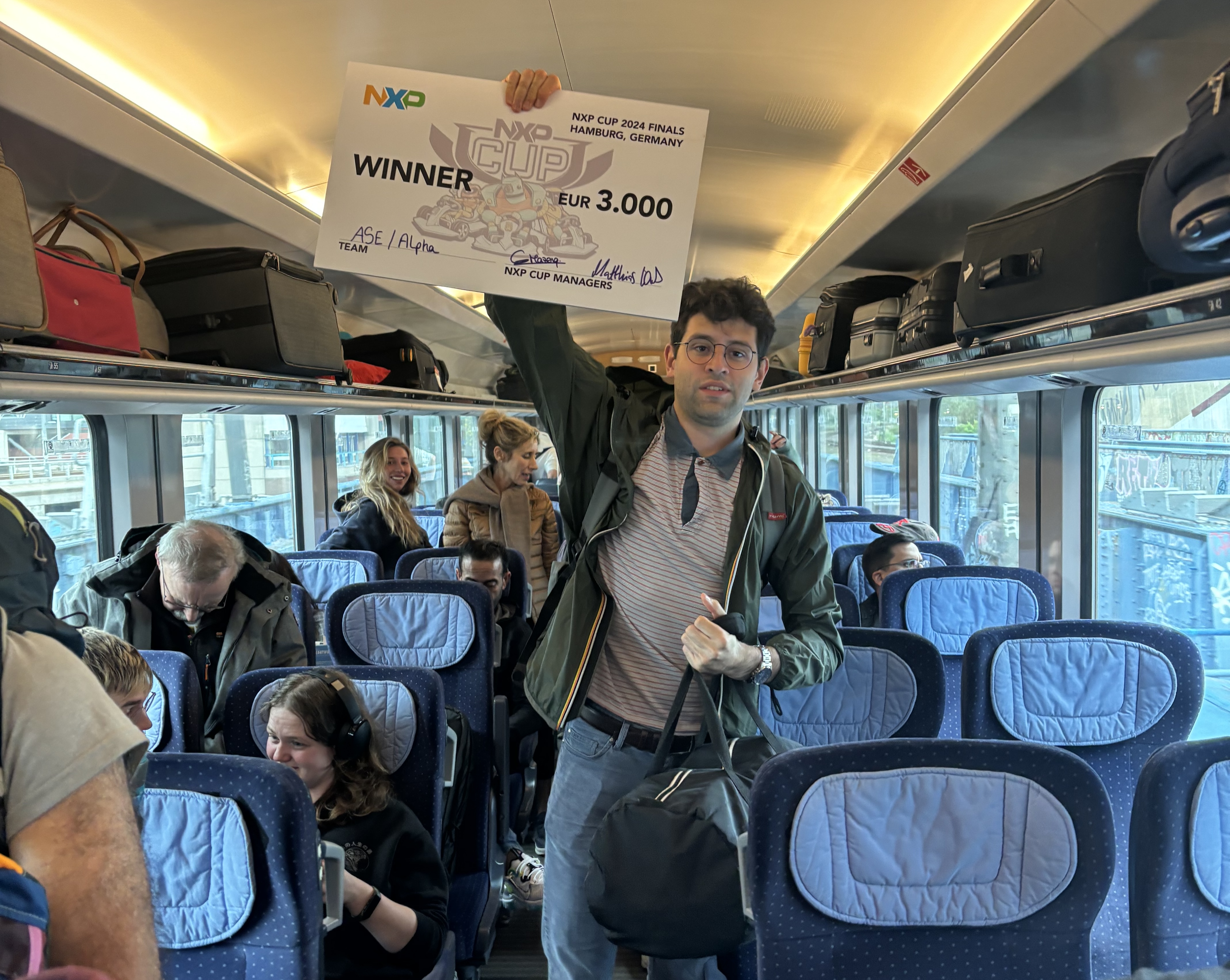 Eduardo holding the winner&#39;s cheque in the train to Amsterdam